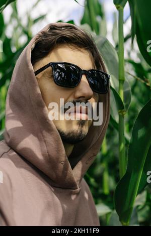 Portrait d'un homme à capuchon avec des lunettes sombres, une moustache et une barbe. Banque D'Images