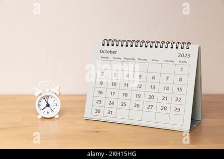 Calendrier octobre 2023 et petite horloge vintage sur le bureau Banque D'Images