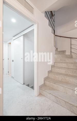 Escalier en colimaçon avec escalier blanc et rambarde sur le mur à l'intérieur de l'appartement moderne avec couloir. Banque D'Images