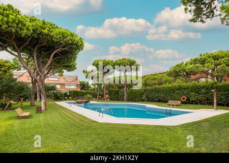 Arrière-cour de complexe résidentiel avec jardin et piscine avec arbres autour le jour ensoleillé. Banque D'Images