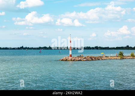 Rocky Pier sur le lac Balaton lors d'une journée ensoleillée d'été, les gens se bronzer sur la plage, surfer sur l'eau bleue azur Banque D'Images