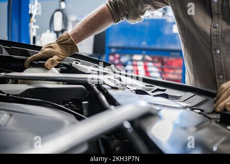 Mécanicien automobile professionnel contrôle du niveau de liquide de refroidissement du moteur. Thème de l'entretien régulier du véhicule. Banque D'Images