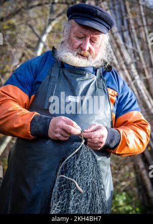 Alt Schlagsdorf, Allemagne. 19th novembre 2022. Le pêcheur Walter Piehl prépare le filet de transport au lac Neuschlagsdorf. Trois semaines après le début de la saison de la carpe, cependant, la carpe de Noël ne va pas encore dans le filet dans le Mecklembourg; seulement la carpe d'herbe et le brochet se fauchent dans l'équipement de pêche. Le temps est trop chaud et les poissons sont encore trop agiles. Walter Piehl, ancien pêcheur en haute mer de 65 ans, est l'un des rares pêcheurs de Mecklembourg-Poméranie occidentale à attraper de la carpe avec des filets de transport dans des lacs naturels. Credit: Jens Büttner/dpa/Alay Live News Banque D'Images