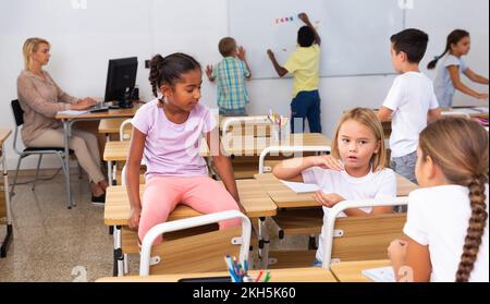 Les camarades de classe de la préadolescence sont joyeux et parlent en retrait entre les leçons Banque D'Images