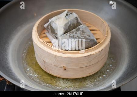 Cuire à la vapeur la nourriture traditionnelle de Cantoness nommée riz collant enveloppé de feuilles de lotus Banque D'Images