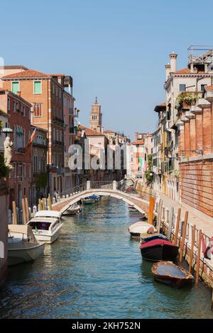 Passerelle sur le canal avec bateaux amarrés et bâtiments résidentiels de style architectural ancien, Dorsoduro, Venise, Vénétie, Italie. Banque D'Images