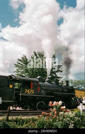 Un moteur à vapeur d'époque qui fume dans l'air à l'extérieur de la gare de Conway Scenic Railway. North Conway, New Hampshire. Image capturée sur un réseau Fi analogique Banque D'Images