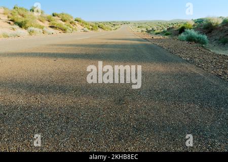 Matin dans le désert avec une route vide ou une route nationale en haut passant par le désert. Horizon lointain, été chaud au désert de Thar, Rajasthan, Inde. Banque D'Images