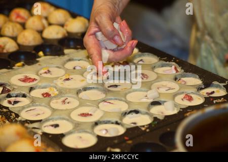 Takoyaki, boules grillées de poulpe en dés, préparées au festival de l'obon de Takadanobaba à Tokyo, au Japon Banque D'Images