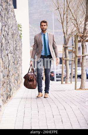 Aller où vous voulez. un beau et élégant jeune homme d'affaires marchant dans un cadre urbain. Banque D'Images
