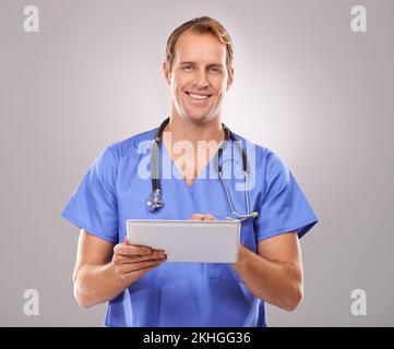 Diagnostic numérique. Photo en studio d'un beau médecin de sexe masculin à l'aide d'une tablette numérique. Banque D'Images