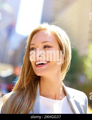 Grande ville, grands rêves. Une photo courte d'une belle femme qui marche dans la ville dans la journée. Banque D'Images