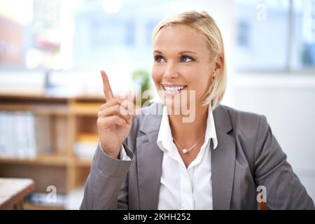 Maintenant c'est une idée. Une jeune femme d'affaires attirante pointant du doigt. Banque D'Images