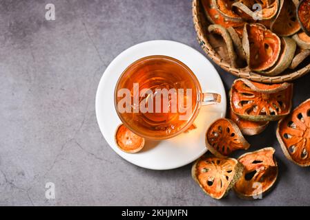 Thé Bael sur verre avec tranches de bael séchées sur fond sombre, jus de Bael - thé sec aux fruits Bael pour la santé - Aegle marmelos - vue du dessus Banque D'Images