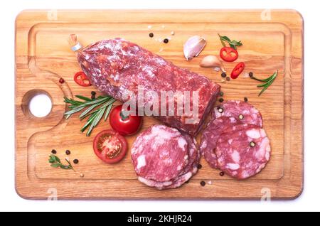 Saucisse de salami fumée et sèche sur planche à découper en bois isolée sur fond blanc Banque D'Images