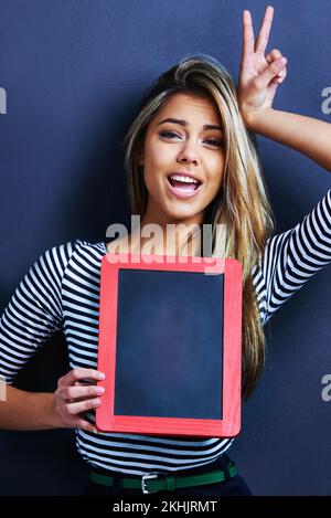 Shell agrémentez votre texte de son charme original. une jeune femme jouée avec un tableau noir. Banque D'Images