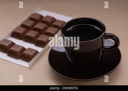 photo d'une tranche de chocolat et de deux tasses de café sur la table Banque D'Images