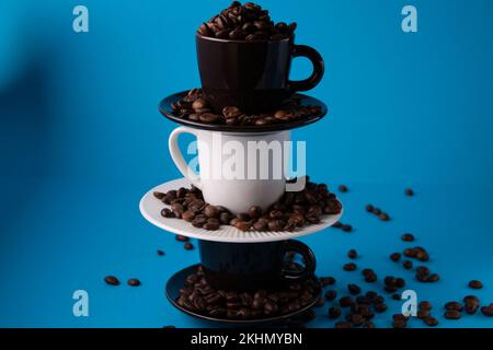 photo d'une tasse avec des grains de café sur une pyramide de tasses Banque D'Images