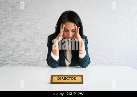 La jeune directrice caucasienne se sent stressée sur le lieu de travail, a des problèmes à travailler à un bureau vide. Une femme ethnique frustrée inquiète de l'entreprise Banque D'Images