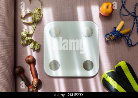 Vue du haut des femmes en bonne santé coulisseaux de sport et équipements de fitness sur fond de tapis de yoga. Accessoires de gym spots équipement sur le sol et scal Banque D'Images