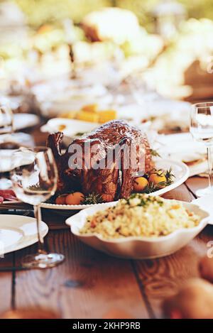 Thanksgiving, table et nourriture avec dinde, poulet ou volaille pour les repas de fête de vacances par un fond flou. Cuisine fine, célébration ou arrière-cour Banque D'Images