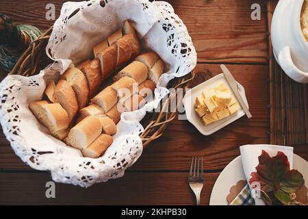 Table, pain et beurre pour le dîner, le déjeuner ou les fêtes pour Thanksgiving, noël ou anniversaire. Table de salle à manger, nourriture et décoration pour la fête Banque D'Images