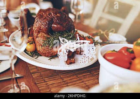 Thanksgiving, nourriture et viande rôtie pour le dîner sur une table à manger lors d'une fête, d'une célébration ou d'un événement. Repas de Noël, de poulet et de luxe ou de fête à un Banque D'Images