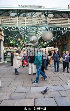 Les gens à l'extérieur et à l'extérieur et les achats dans le marché Apple. Des décorations de Noël sont accrochées au toit. Covent Garden, Londres, Angleterre, Royaume-Uni Banque D'Images