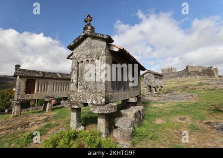 Un vieux grenier (espigueiros) et le château au-dessus du village de Lindoso dans le Parque Nacional da Peneda-Geres, dans le nord du Portugal. Banque D'Images