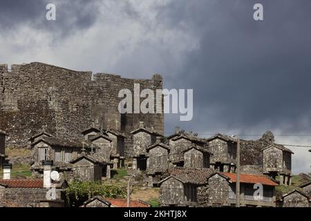 Un vieux grenier (espigueiros) et le château au-dessus du village de Lindoso dans le Parque Nacional da Peneda-Geres, dans le nord du Portugal. Banque D'Images