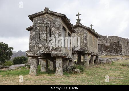 Un vieux grenier (espigueiros) et le château au-dessus du village de Lindoso dans le Parque Nacional da Peneda-Geres, dans le nord du Portugal. Banque D'Images