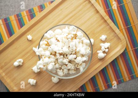 pop-corn dans un bol sur un bureau en bois Banque D'Images
