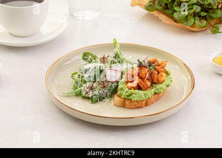 Portion de pain grillé à l'avocat avec crevettes et salade Banque D'Images