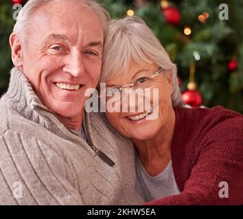 Couple senior, portrait et joyeux noël à la maison, maison et bonheur, amour et soin ensemble pour les vacances d'hiver. Homme, femme et vieux Banque D'Images