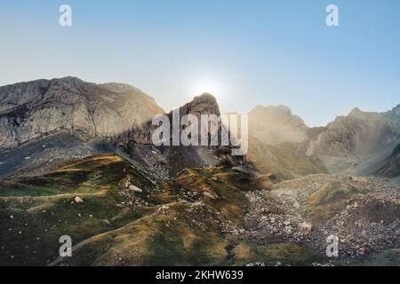 Coucher de soleil dans les Pyrénées aragonaises, le soleil se couche derrière la montagne créant des vagues de lumière sur les bords. Banque D'Images