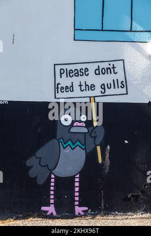 Ne pas nourrir les Gulls, le dessin animé sur le côté d'un restaurant à Brixham Harbour, Devon Banque D'Images
