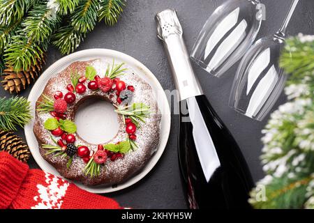 Gâteau de Noël décoré de graines de grenade, de canneberges et de romarin. Pose à plat Banque D'Images