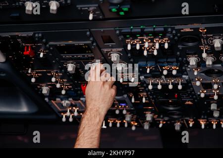 La main pilote contrôle les interrupteurs à bascule de l'avion pour le décollage et l'atterrissage en vol Banque D'Images