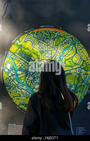 Un touriste regarde un plan de rue par Pulteney Bridge à Bath Spa, Somerset, Angleterre, Royaume-Uni Banque D'Images