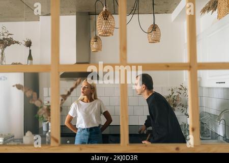 Vue à distance de mari en colère collant, élevant la voix, criant à ignorer la jeune femme petite amie debout dans la salle de cuisine. Concept de problèmes familiaux. Banque D'Images