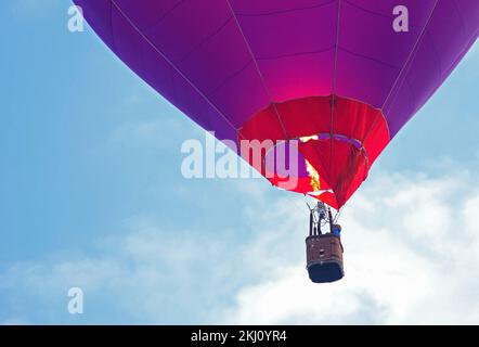 Panier ballon d'air chaud en gros plan. Flamme jaune, personne dans le panier. Banque D'Images