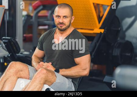 Robuste, musclé, beau chauve homme, bodybuilder, exécution abs croque sur le banc de déclin dans la salle de gym, se reposant avant les ensembles. Photo de haute qualité Banque D'Images