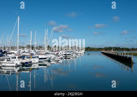 Bateaux dans le port de plaisance de Lymington Hampshire avec ciel bleu et réflexions claires dans l'eau Banque D'Images
