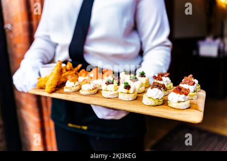 Réception de mariage réception de réception avec hors-d'œuvre et canapés servis par des serveurs dans le jardin pour leurs invités Banque D'Images