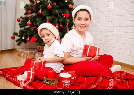 Les frères déballer leurs cadeaux de Noël. Banque D'Images