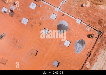 Des tranchées sont creusées sur le chantier de construction afin de verser du béton dans la structure de construction des fondations Banque D'Images