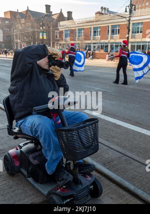 Detroit, Michigan, États-Unis. 24th novembre 2022. Un photographe en fauteuil roulant motorisé photographie le défilé de Thanksgiving de Detroit, officiellement le défilé de Thanksgiving de l'Amérique. Crédit : Jim West/Alay Live News Banque D'Images