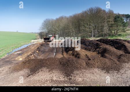 Retourner un tas de fumier pour faire du compost à répandre sur les terres agricoles, ce qui aide à améliorer la qualité du sol. North Yorkshire, Royaume-Uni. Banque D'Images