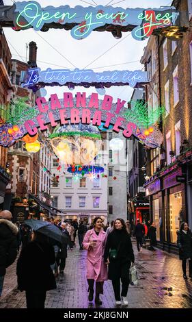 Londres, Royaume-Uni. 24th novembre 2022. Les amateurs de shopping brave le temps humide pour découvrir et apprécier les lumières de Noël dans la célèbre rue Carnaby de Soho. L'installation de cette année s'appelle « Carnaby Celebore » et célèbre 25 ans des lumières de Noël de Carnaby Street. Credit: Imagetraceur/Alamy Live News Banque D'Images