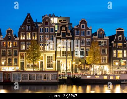 Amsterdam dans la soirée, des maisons hollandaises typiques et des bateaux à moteur le long de la rivière Amstel Banque D'Images